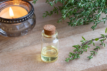 A bottle of thyme essential oil with fresh thyme twigs