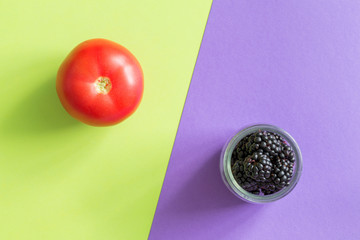 blackberries and tomatoes on a violet-green background