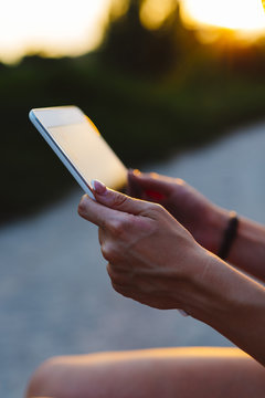 Woman's Hands Holding Digital Tablet At Sunset, Close-up