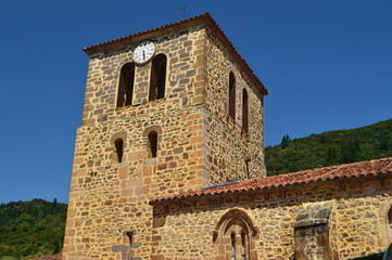 Fototapeta na wymiar Clock Tower Of The Old Church Of San Vicente In Pots Dated From Medieval Times In Villa De Potes. Nature, Architecture, History, Travel. July 30, 2018.Potes, Cantabria, Spain