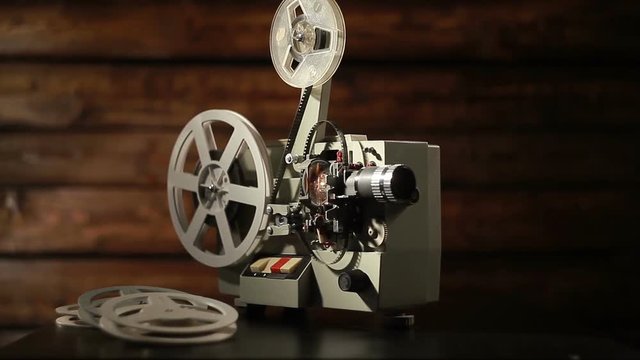 film projector on a black background with dramatic lighting and selective focus.