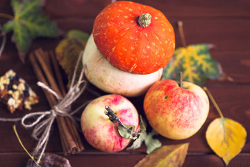  Set of pumpkins, apples and nuts with maple leaves on the wooden background. Autumn mood. Thanksgiving concept. Healthy food, diet, lifestyle and holiday theme. Top view. Close up.