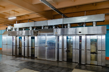 Modern bakery in confectionery factory. Industrial ovens for baking biscuits, cakes and cookies 