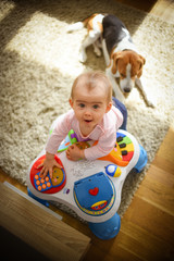 Fototapeta premium Baby girl stands next to cafe table in living room