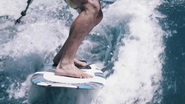 Closeup wake surfing feet and toes on blue lake
