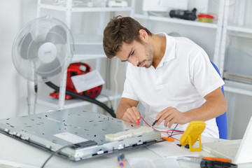 handsome electrician testing induction hobs