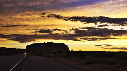 Naklejka na ściany i meble Silhouette of a mountain on a desert at sunset