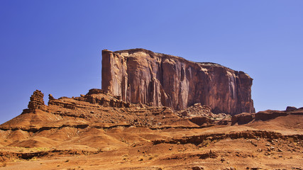 Fototapeta premium Big wall of rock on a desert on a blue sky as background