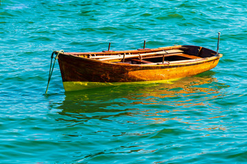Small wooden boats docked in the sea. Beautiful shades of blue, green and turquoise colors.