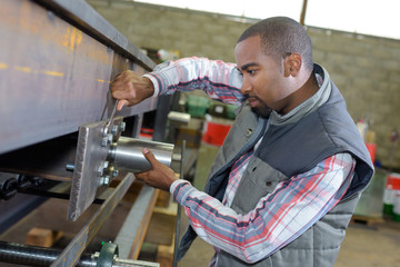 Man adjusting machine with spanner