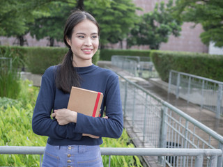 beautiful young Asia woman with reading book at outdoor garden.