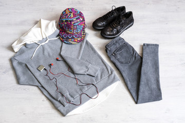 Teen clothing set: grey sweatshirt, black jeans, boots in military style and colored cap