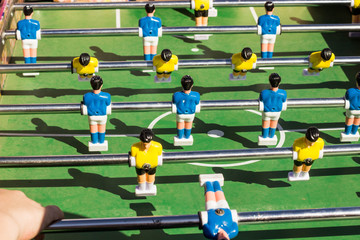 A game of table football with yellow and blue rivals