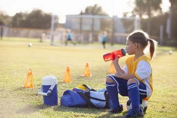 A soccer player takes a break for water. 