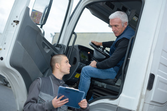 senior truck driver taking to manager