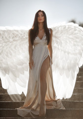 Fine art photo of a woman in white dress as an angel