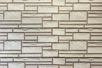 Wall of light beige bricks of different sizes. Background with texture brickwork.