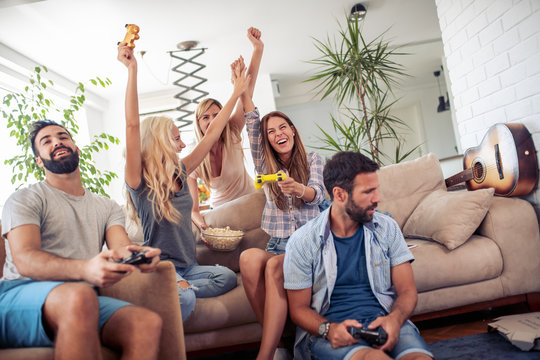 Excited Friends Playing Video Games At Home