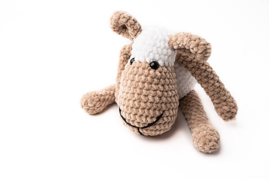Beautiful soft sheep stuffed toy gift for a baby with thick yarn mane in brown, white color hand made with crochet technique from wool yarn. White Isolated background.
