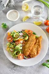Vegetable salad and breaded chicken breast