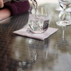 Pouring a glass of sparkling water and watching its reflection bounce off the table