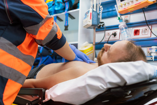 Emergency Doctor Resuscitate A Patient In Ambulance. CPR Resuscitation.