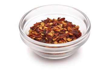 Red chili flakes, ground spice hot pepper, isolated on white background. Close-up.