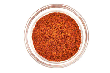 Paprika powder in a glass cup, isolated on white background. Top view.