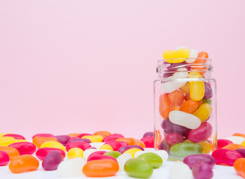 A Glass Jar Full Of Colourful Jelly Bean Candy In A Sweet Shop With A Pink Background And Copy Space