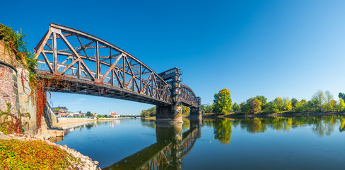 Obraz premium Old Town Railway Bridge in Magdeburg, Elbe river and downtown at Autumn