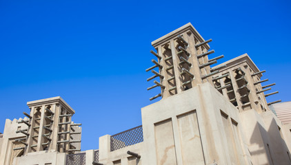 Obraz premium traditional Arab wind tower for air conditioning and cooling on top of building in Dubai, United Arab Emirates