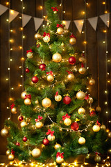 christmas tree with new year decoration and lights on wooden background, holiday concept backdrop