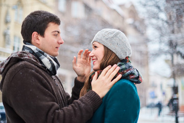 Happy couple playful together during winter holidays vacation outside in snow park