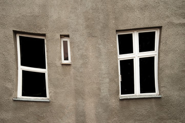 distorted window with white frame on grey old wall architecture background