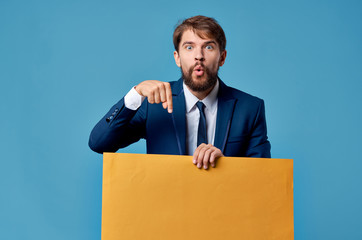 surprised man shows with his finger on a yellow sheet of paper place free signs