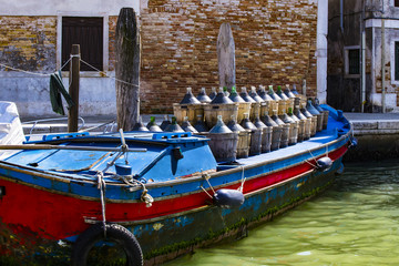 Fototapeta na wymiar Bottles with wine on a barge in the middle of the water channel in Venice.