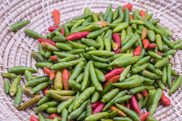 Red and green chilly pepper in basket background.