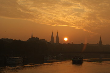 Sunrise in Bremen City view on Weser river with a transport vessel boat going on weser