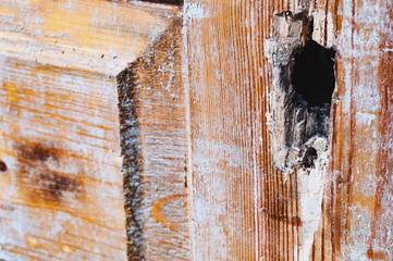Fragment of old dirty wooden door with hole for lock