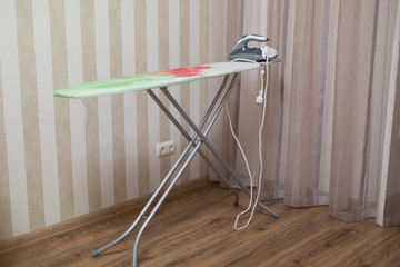 Ironing board. Ironing Board is in the corner of the room. iron.