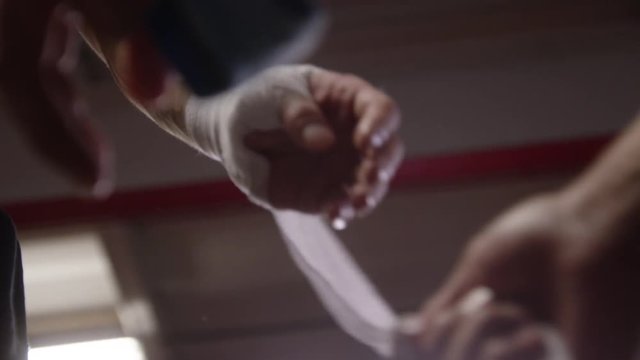 Boxer getting hands unwrapped by trainer