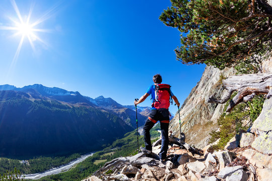 Hiker takes a rest observing a mountain panorama. Mont Blanc Massif, Italian Alps, Val D'Aosta, Italy. Concept: adventure, travel, outdoor.