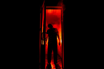 Silhouette of an unknown shadow figure on a door through a closed glass door. The silhouette of a...
