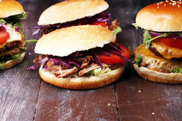 Tasty fresh meat burgers with salad and cheese. Homemade angus burger and Pulled pork sandwiches.