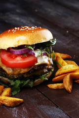 Tasty fresh meat burgers with salad and cheese and potato wedges. Homemade angus burger.