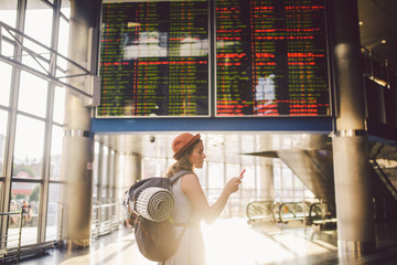 Theme travel and tranosport. Beautiful young caucasian woman in dress and backpack standing inside...