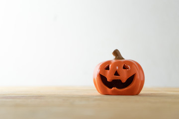 Halloween Pumpkin miniature on plank wood table on white background.
