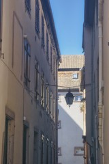 stara wąska alzacka ulica z wiszącą lampą pośrodku
