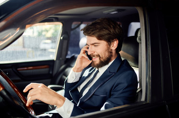 Business man talking on the phone sitting in a car luxury