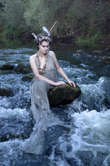 covering his eyes mermaid sitting on the rocks in the river, pretends to be a modest insidious evil, attracts travelers, then drown them will be in the cold fast flowing water, mermaids are all, prete
